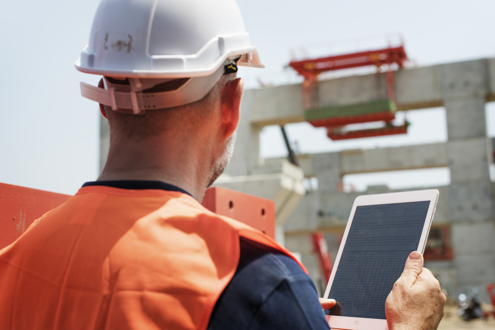 Construction worker holding an iPad at construction site