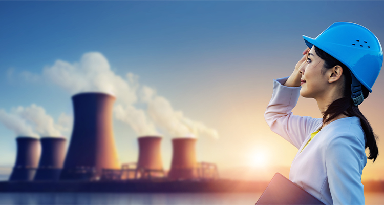 Female engineer looking at nuclear power plant in the midst of decommissioning project