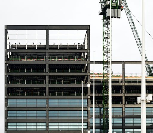 Image of a building being worked on with construction equipment to support built environment article