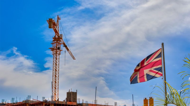 Image of a construction site with scaffolding and machinery with the Union Jack flag next to it to support Construction Industry Scheme article