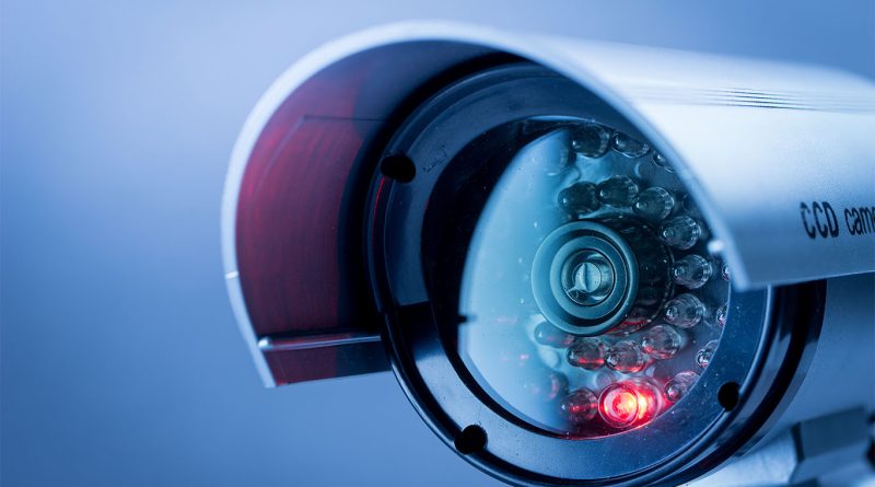 Close-up image of a grey security surveillance camera with a red light on to support building site security article