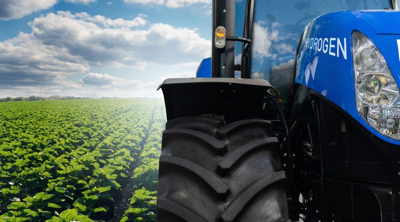 Digital image of a hydrogen-powered tractor driving through a field on a clear day