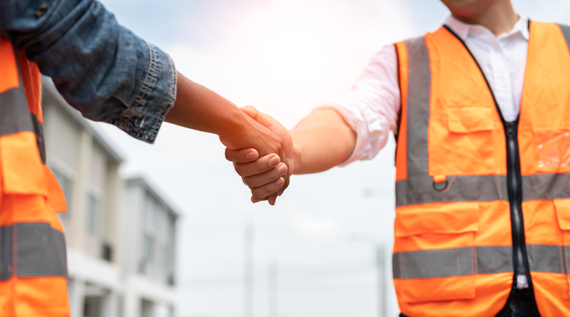 Image of two subcontractors in high visibility gear shaking hands