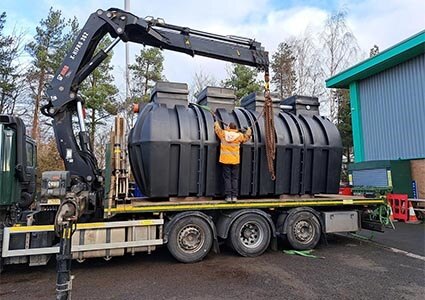 Black waste tank on low-loader