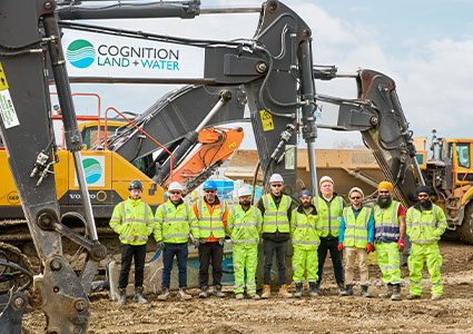 Cognition staff standing in front of heavy plant