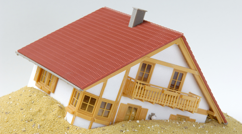 Model house sinking into sand to support construction insolvencies article