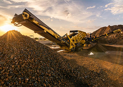 Heavy and mobile machinery in a quarry to transform stone into construction material