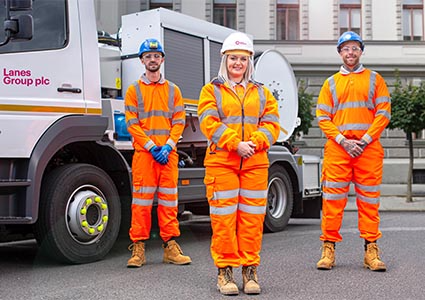 Three lanes group workers in High Vis clothing standing in front of white truck