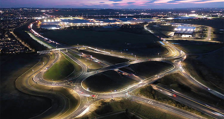 Aerial view of a roundabout lit up by street lights as dawn breaks