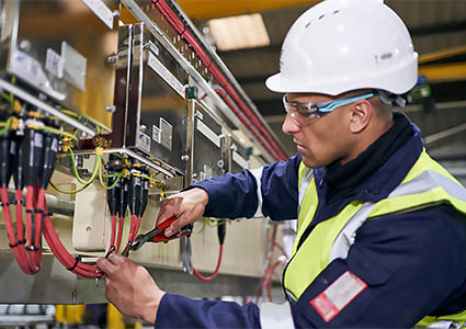 Woodward Group technician tying cables on equipment