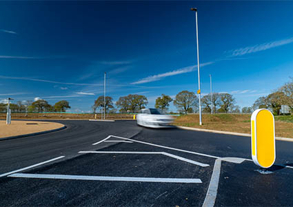 Image of a blurry white car on a road junction