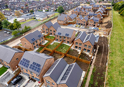 Aerial shot of a housing development with solar panels on roofs