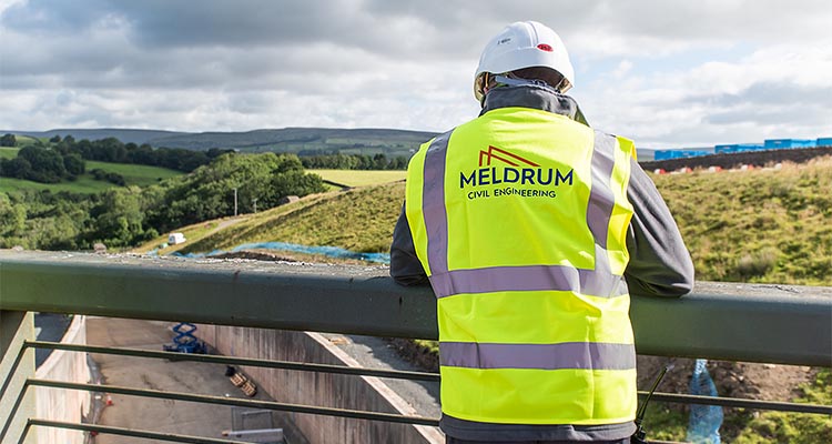 Meldrum Group worker in yellow high visibility jacked overlooking a construction site