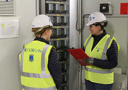 Two Dornan employees inspecting a control panel