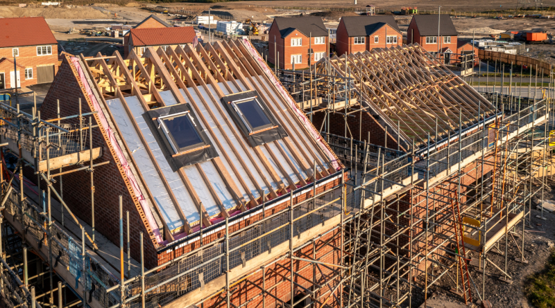 Sustainable homes under construction in the UK using sustainable building materials like timber and recycled steel.