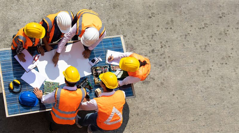 UK construction team gathered around drafting table