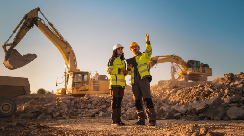 Civil engineers at a UK construction site overseeing excavation work, showcasing heavy machinery and teamwork among leading civil engineering companies.