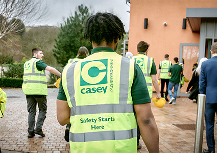 individuals wearing high-visibility vests with the logo and slogan "Casey: Safety Starts Here" and "PRO-ENVIRONMENT"