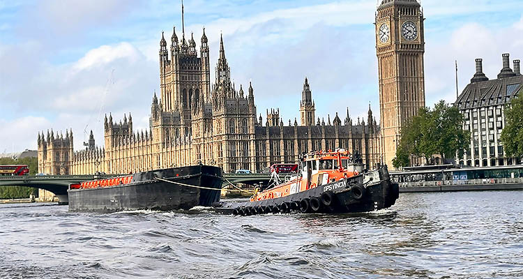 GPS Marine leverages advanced technology and a diverse fleet to redefine European marine infrastructure a tugboat named GPSVINDIN pulling a barge on the River Thames