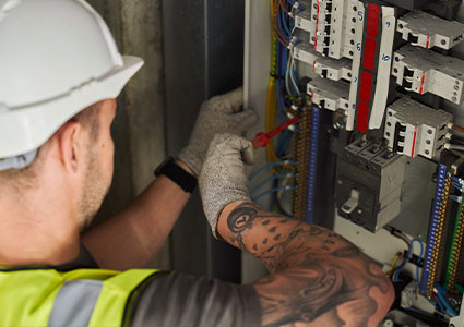 an electrician working on an electrical control panel