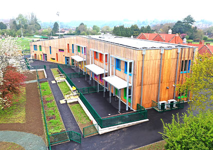 a modern, two-story extension with a distinctive timber-framed exterior and multi-colored window frames