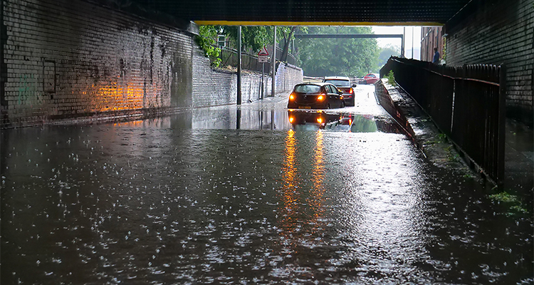 Paul Curtis, Managing Director of Marshalls Water Management, discusses regulation, resilience and building climate-ready infrastructure for tomorrow Two cars stranded in flood water under low bridge in Salford