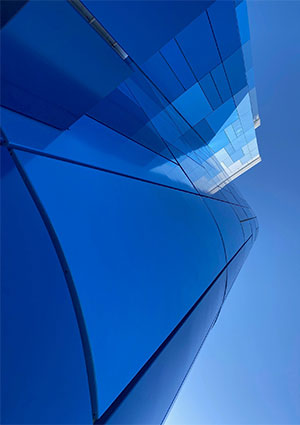 the blue glass facade of a modern business building