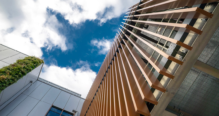 a modern building facade featuring COR-TEN aluminium fins used as a brise soleil for solar shading