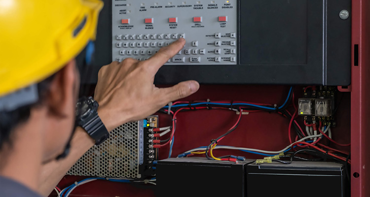 a technician is performing inspection or maintenance on a commercial fire alarm control panel
