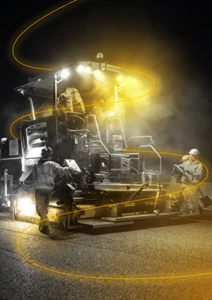 night-time construction work featuring an asphalt paver