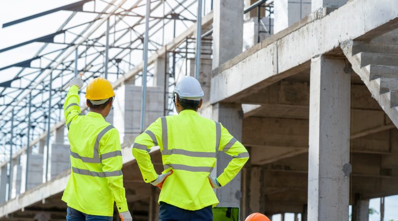 Engineer and architect on a UK housing development as Vistry restructures following a profit warning, illustrating the challenges facing the residential construction sector.