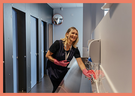 a person cleaning a commercial restroom.