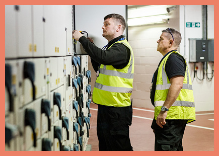 technicians working on a large industrial electrical panelboard