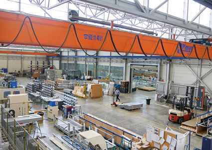 an Abus Kransysteme overhead crane installed within a busy industrial manufacturing facility
