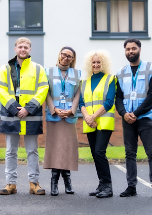 a group of colleagues wearing safety vests and lanyards for visibility and identification.