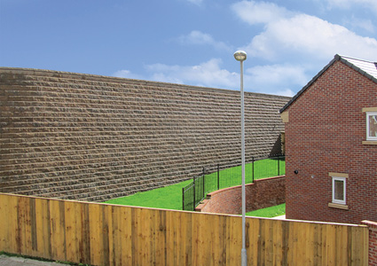 an Allan Block retaining wall system featuring textured, modular concrete blocks designed for structural support in residential landscaping