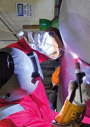 a GTAW TIG welder welding metal with a torch and filler rod