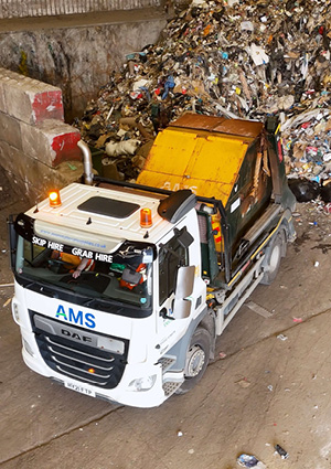  a high-angle, overhead view of a white DAF commercial truck parked inside what appears to be a waste management facility, transfer station, or recycling depot