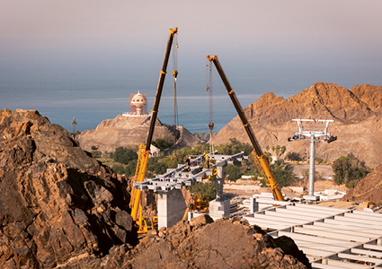 a heavy infrastructure construction site located in a rugged, arid, and mountainous coastal environment