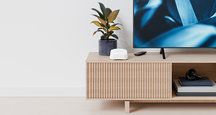 a modern, minimalist living room setup featuring a light wood entertainment console positioned against a plain white wall