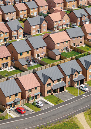 rows of small, dense, modern brick-built houses in a typical English suburban new-build development