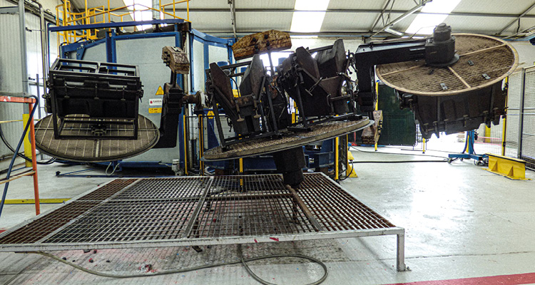 an industrial rotational moulding machine inside a manufacturing facility or factory