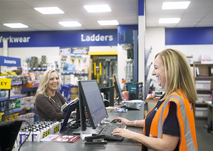 retail staff working behind the service counter at a Screwfix branch