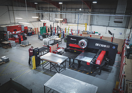 the interior of a spacious industrial manufacturing facility or sheet metal fabrication workshop, captured from an elevated perspective