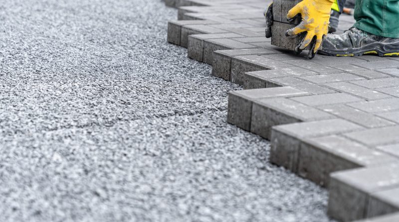 Concrete block paving walkway leading to the entrance of a modern commercial building
